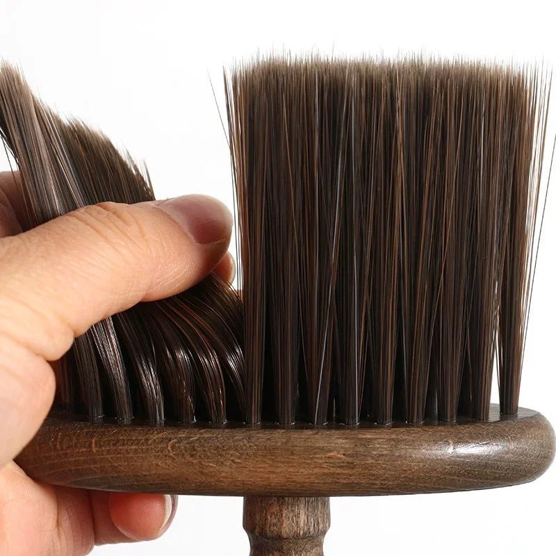 Hand holding a wooden brush with bristles against a white background
