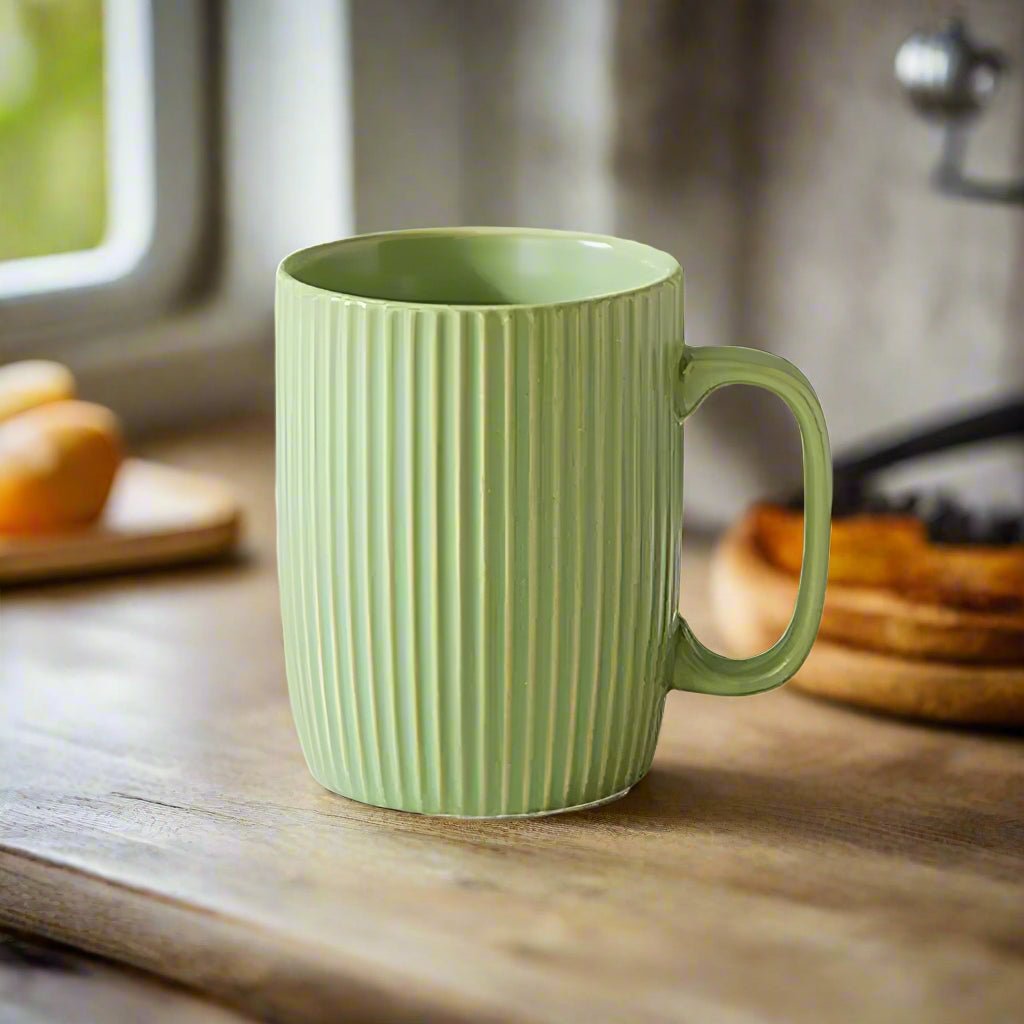 Green mug with ribbed texture on a wooden surface