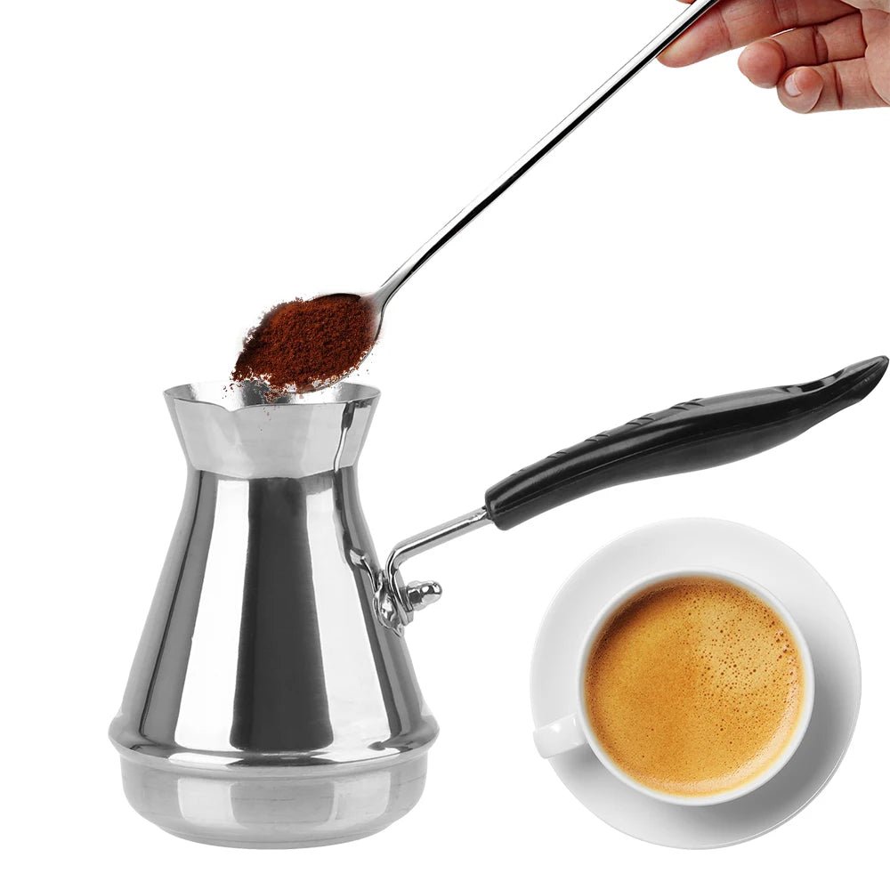 Silver coffee pot with black handle and spoonful of coffee grounds, next to a cup of coffee.