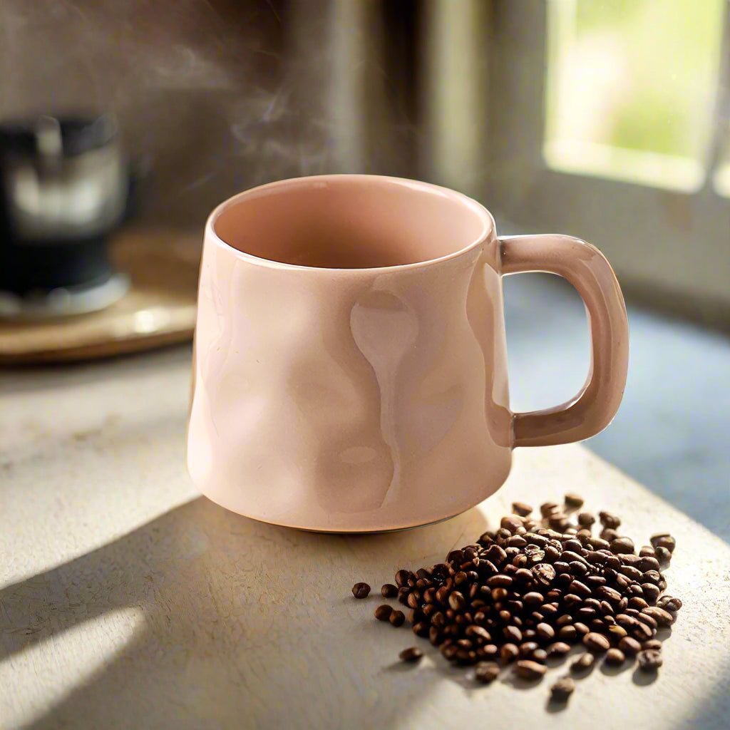 Pink ceramic mug with coffee beans on a table