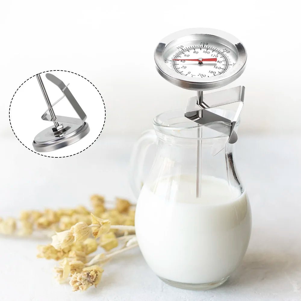 Glass container with milk and a metal thermometer on a white background