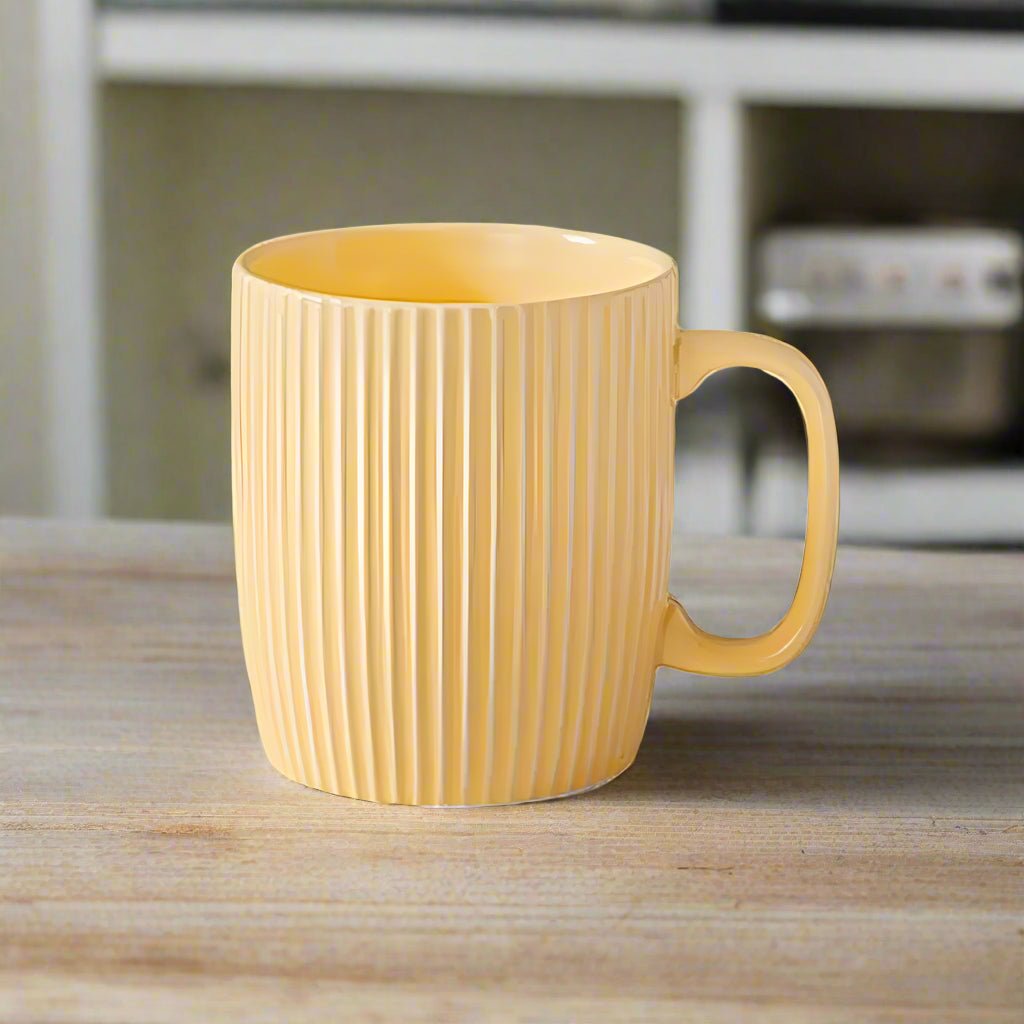 Yellow mug with ribbed texture on a wooden surface