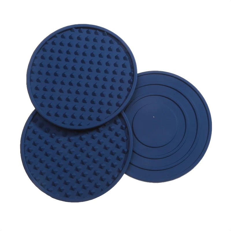 Three blue silicone coasters with textured surface on a white background