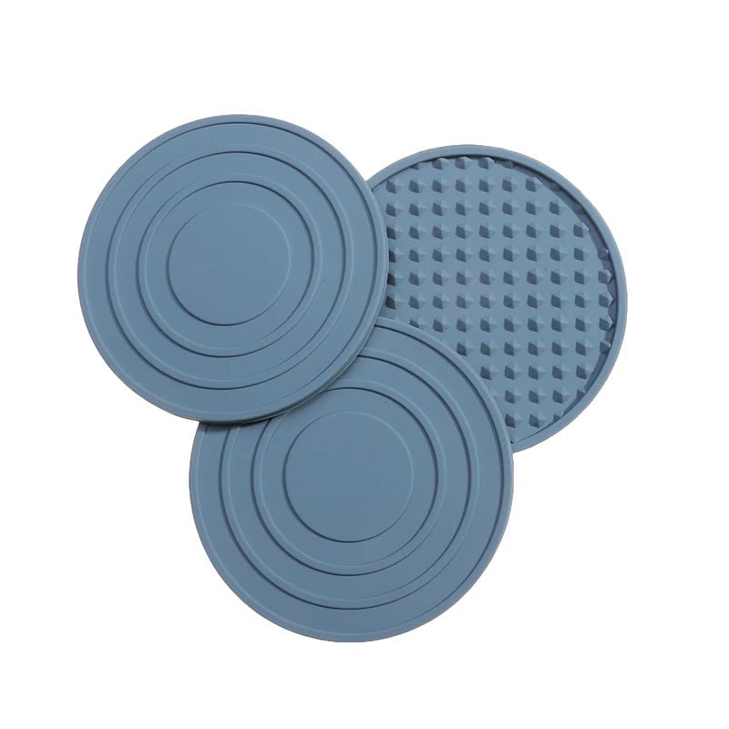 Three blue silicone coasters with different patterns on a white background