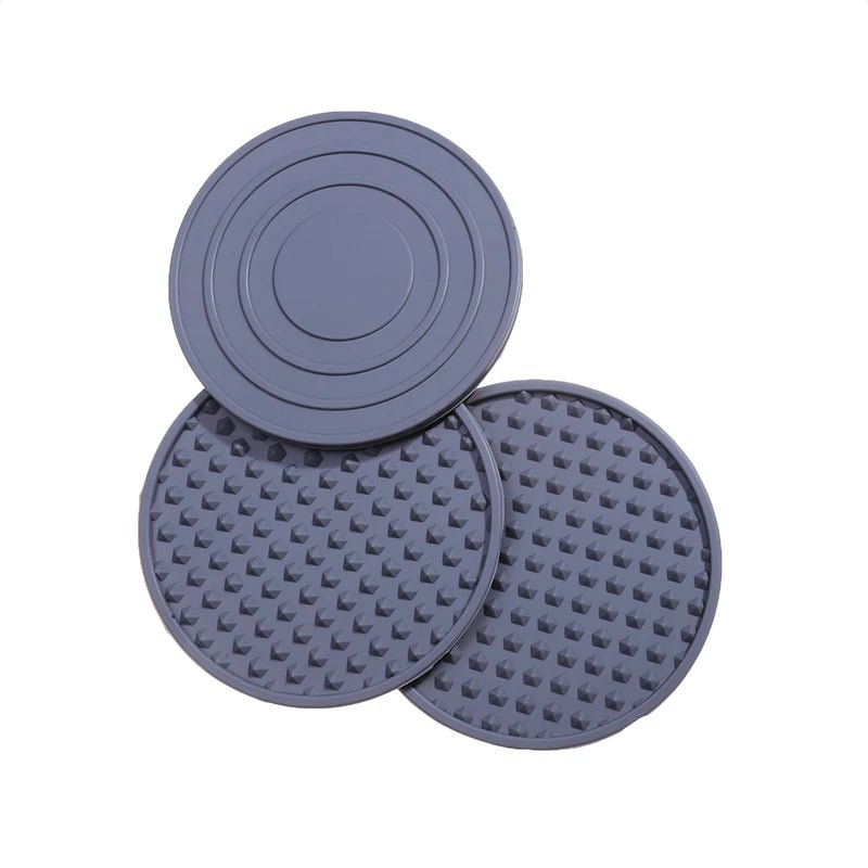 Three blue silicone coasters with textured surfaces on a white background