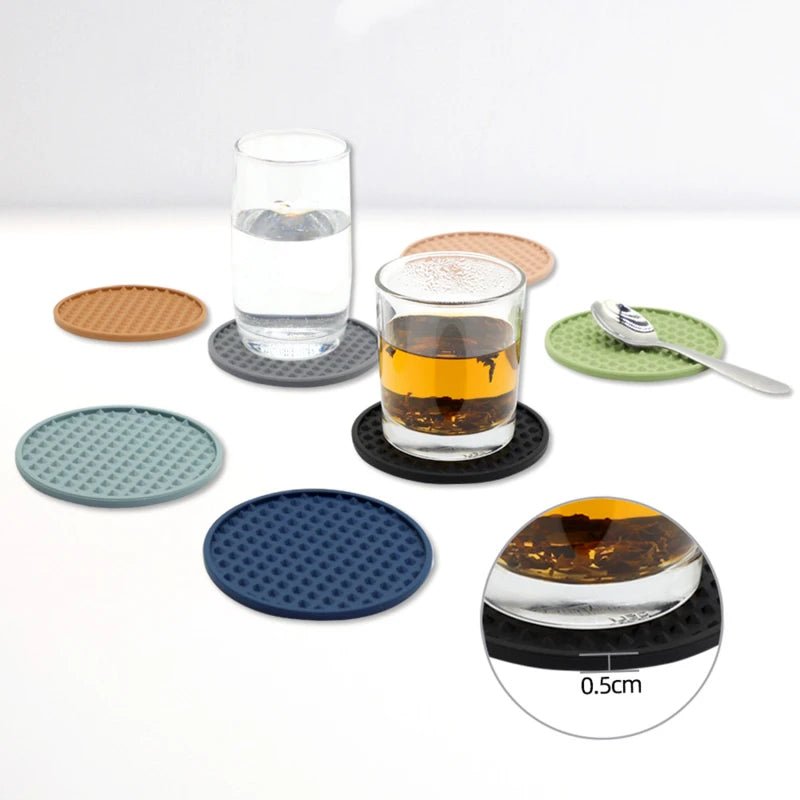 Set of colorful coasters with glasses of water and tea on a white background