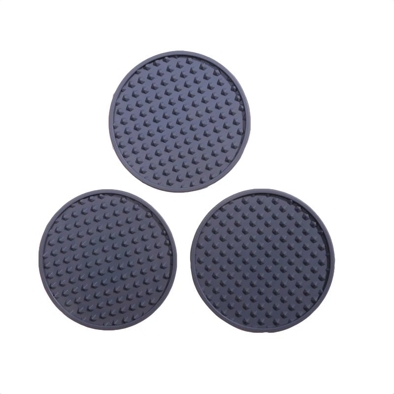 Three round, textured black coasters on a white background