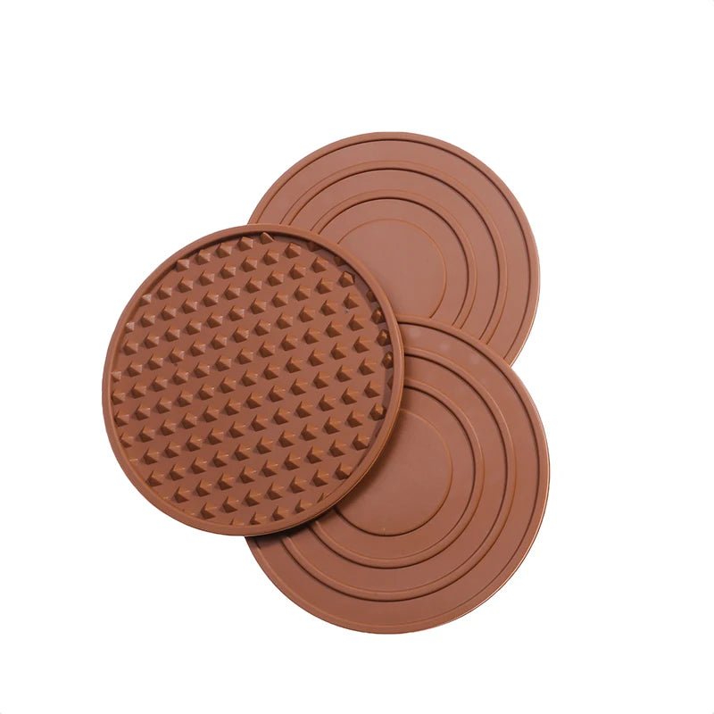 Three brown silicone mats with textured surface on a white background