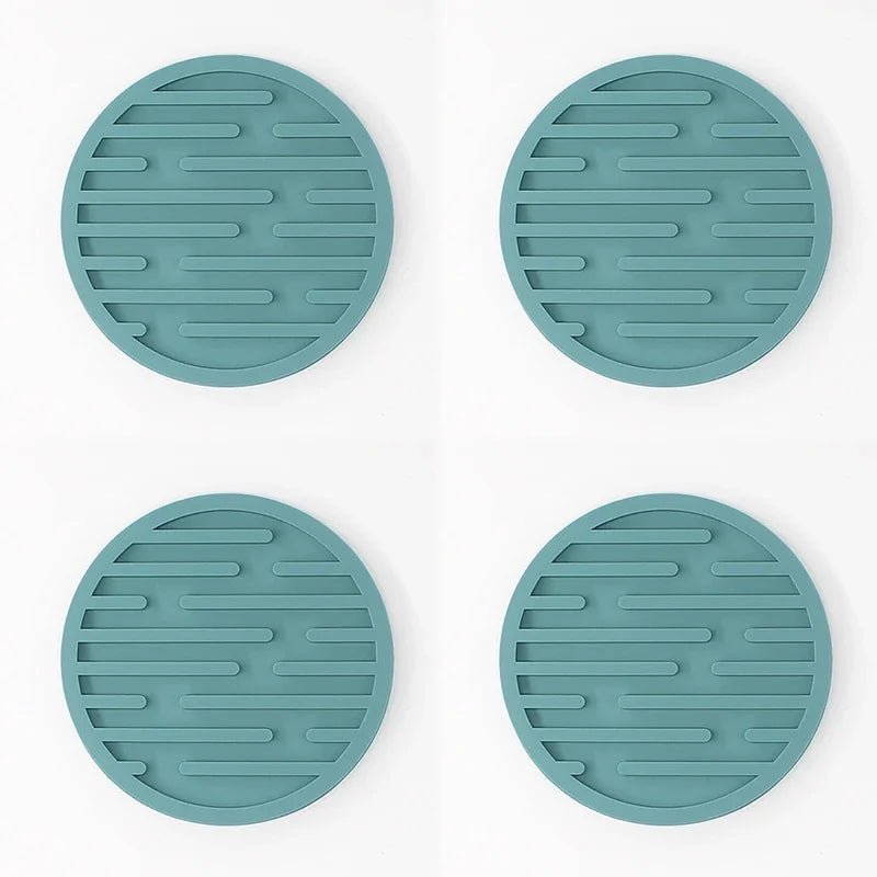Four teal silicone coasters with textured surface on a white background