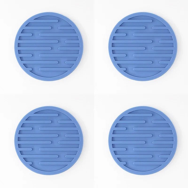 Four blue silicone coasters with textured surface on a white background