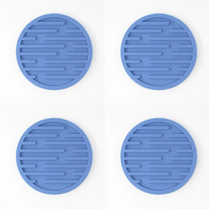 Four blue silicone coasters with textured surface on a white background