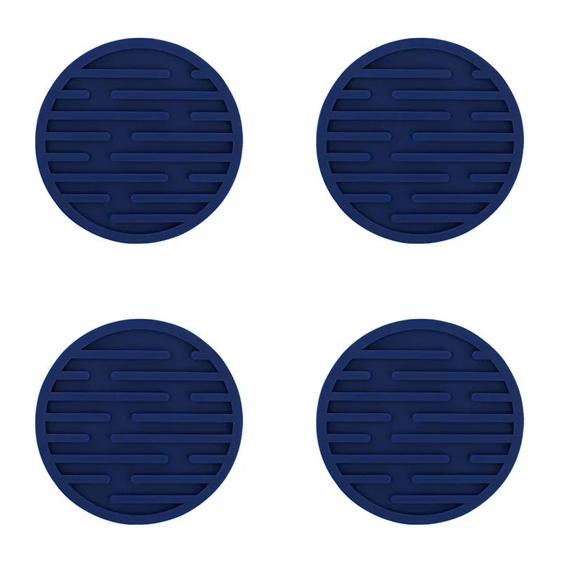 Four blue silicone coasters with textured surface on a white background