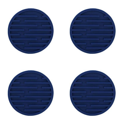Four blue silicone coasters with textured surface on a white background