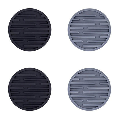 Four round silicone coasters in black and gray on a white background