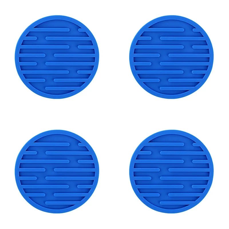 Four blue silicone coasters with textured surface on a white background