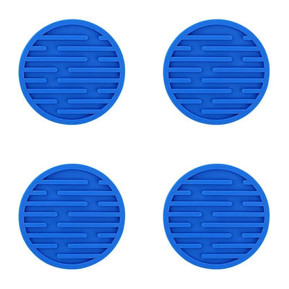 Four blue silicone coasters with textured surface on a white background