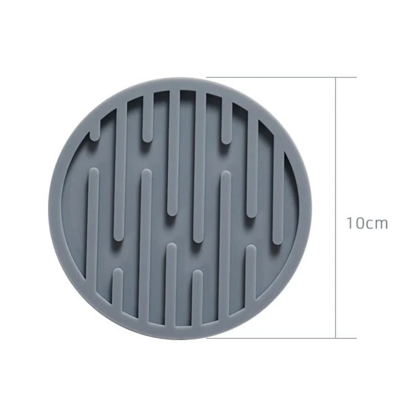 Gray silicone coaster with textured design and measurement label on a white background