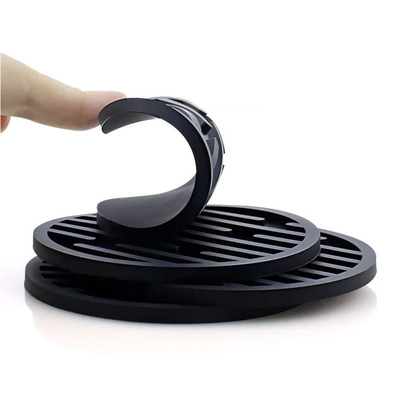 Black silicone coasters with a curved handle on a white background