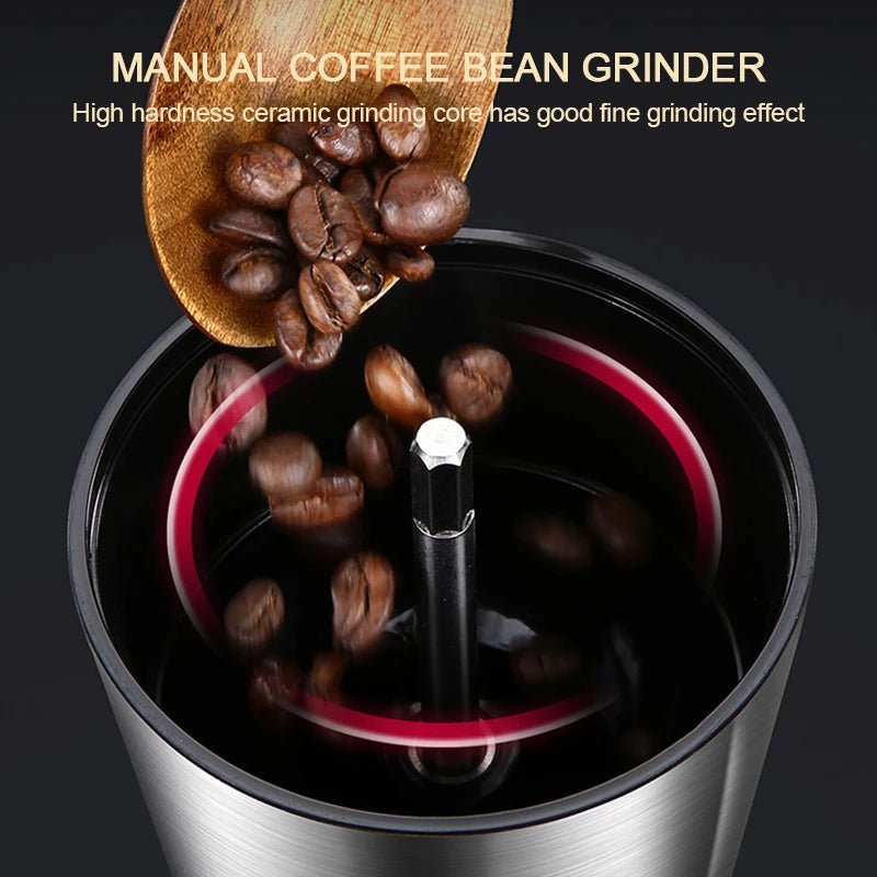Manual coffee bean grinder with coffee beans and a wooden scoop on a dark background
