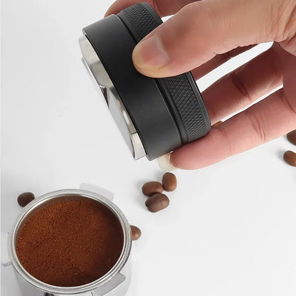 Hand holding a coffee grinder with ground coffee and beans on a white background
