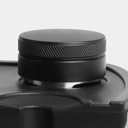 Close-up of a black metal coffee tamper on a light gray background