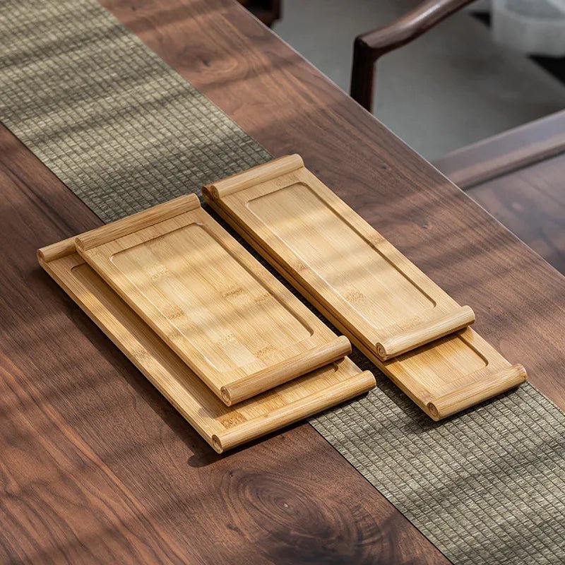 Set of wooden trays on a wooden table with a green placemat.