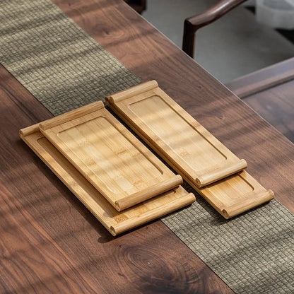 Set of wooden trays on a wooden table with a green placemat.