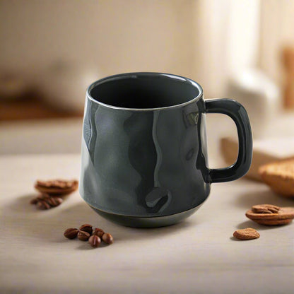 Black mug on a table with coffee beans and pecans