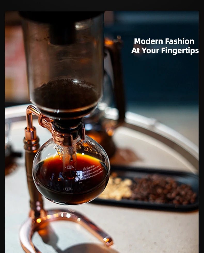 Siphon coffee apparatus with coffee being brewed, coffee beans on a tray in the background.