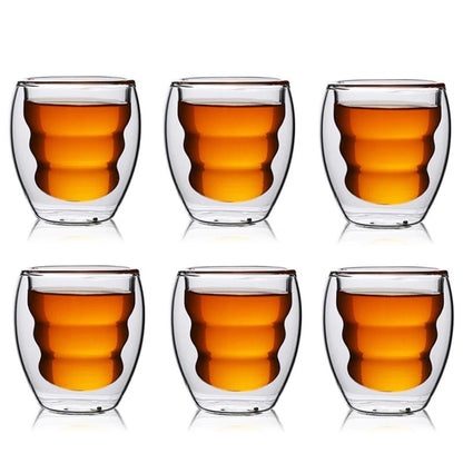 Set of six double-walled glass cups with a drink inside on a white background