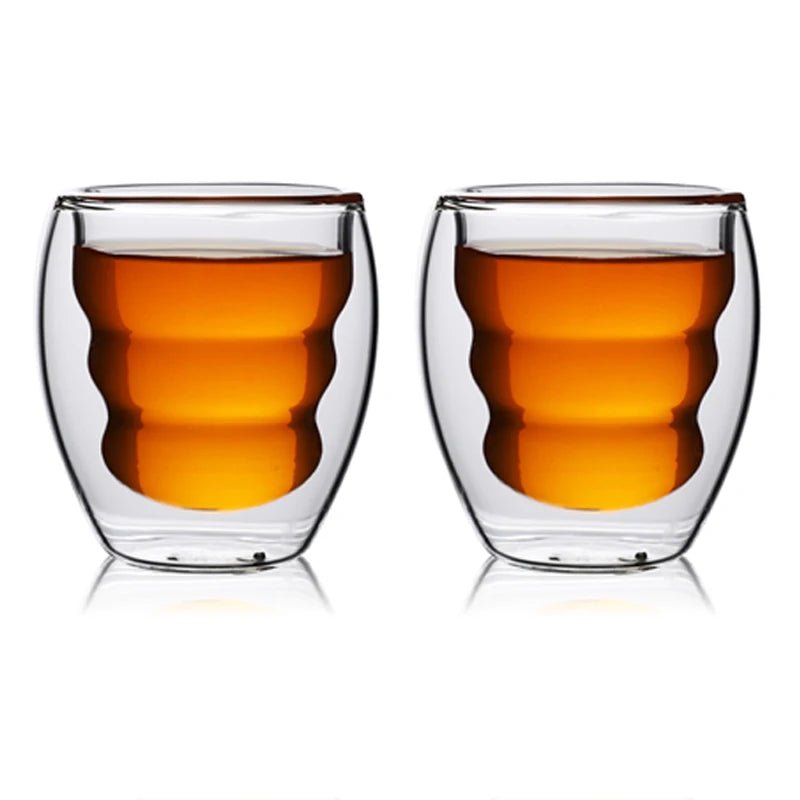 Two double-walled glass cups filled with a warm liquid on a white background