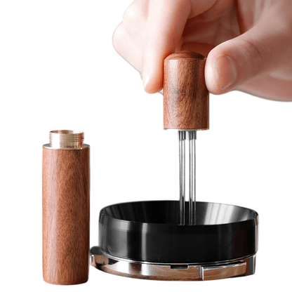 Wooden pepper grinder with black base held by a hand on a white background