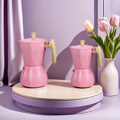 Two pink coffee makers on a wooden stand with a vase of tulips in the background.
