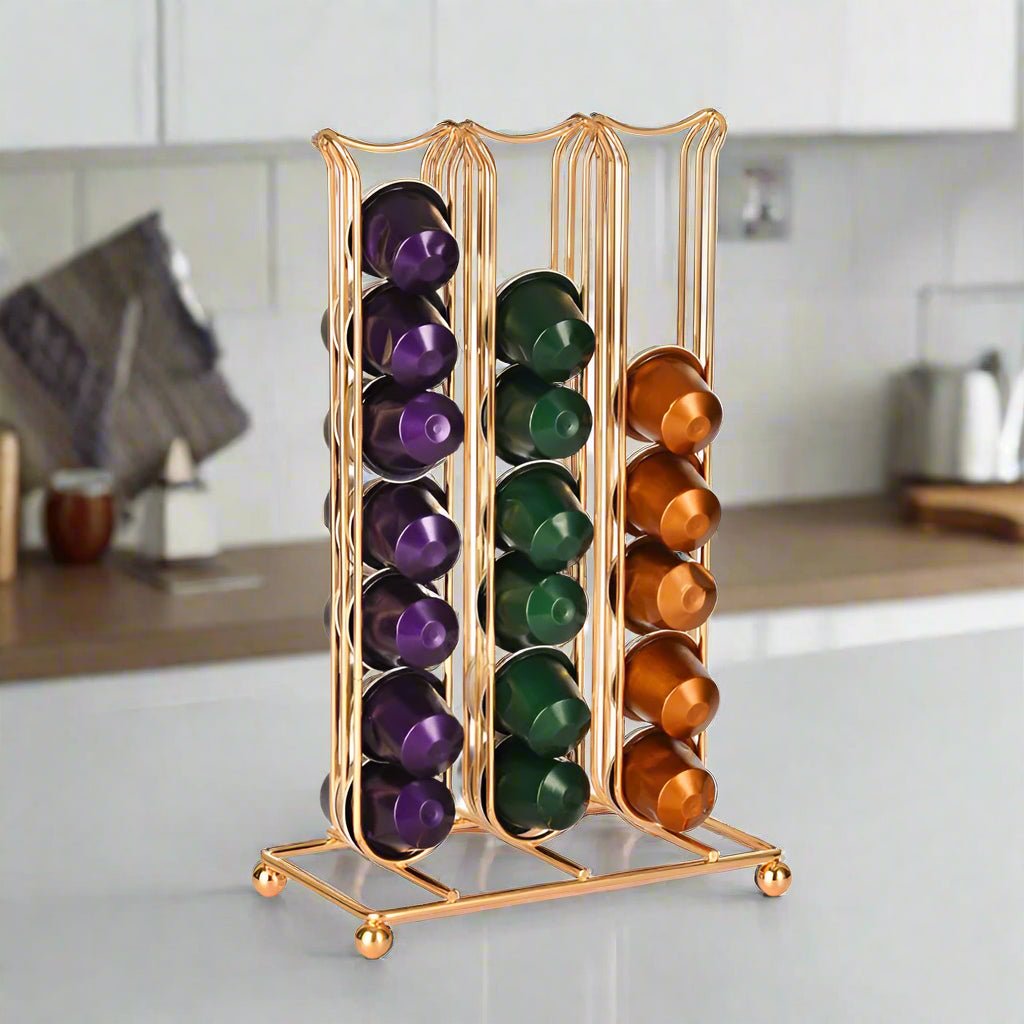 Gold capsule organizer with purple, green, and orange capsules on a kitchen counter.