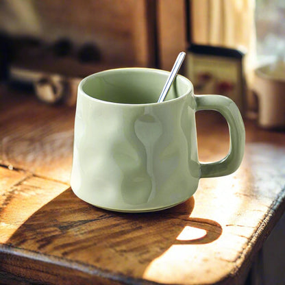 Green mug with a spoon on a wooden surface