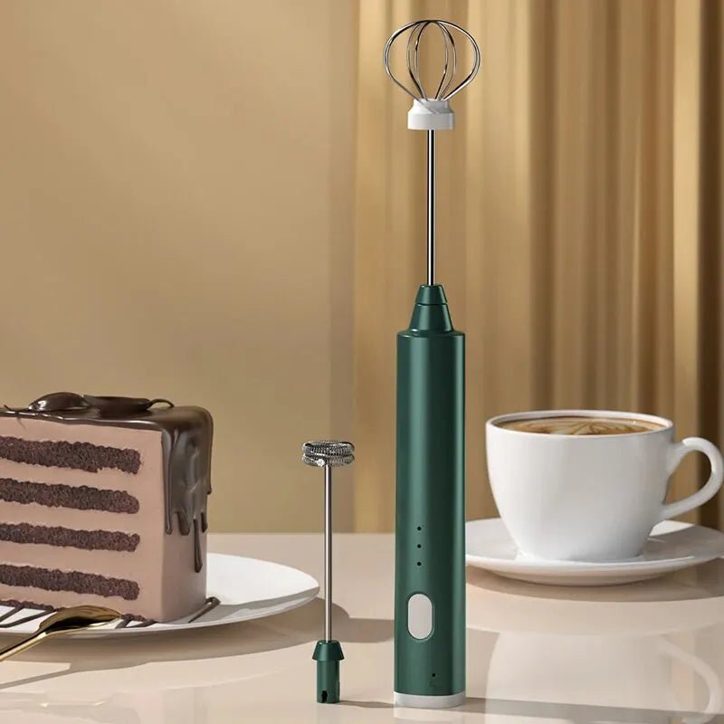 Green handheld milk frother next to a cup of coffee and a slice of cake on a beige background
