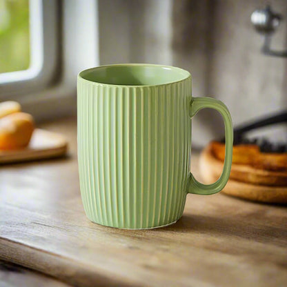 Green mug with ribbed texture on a wooden surface