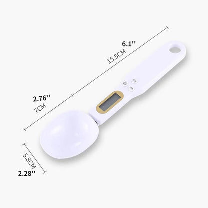 White digital measuring spoon with gold accents and measurements labeled on a white background