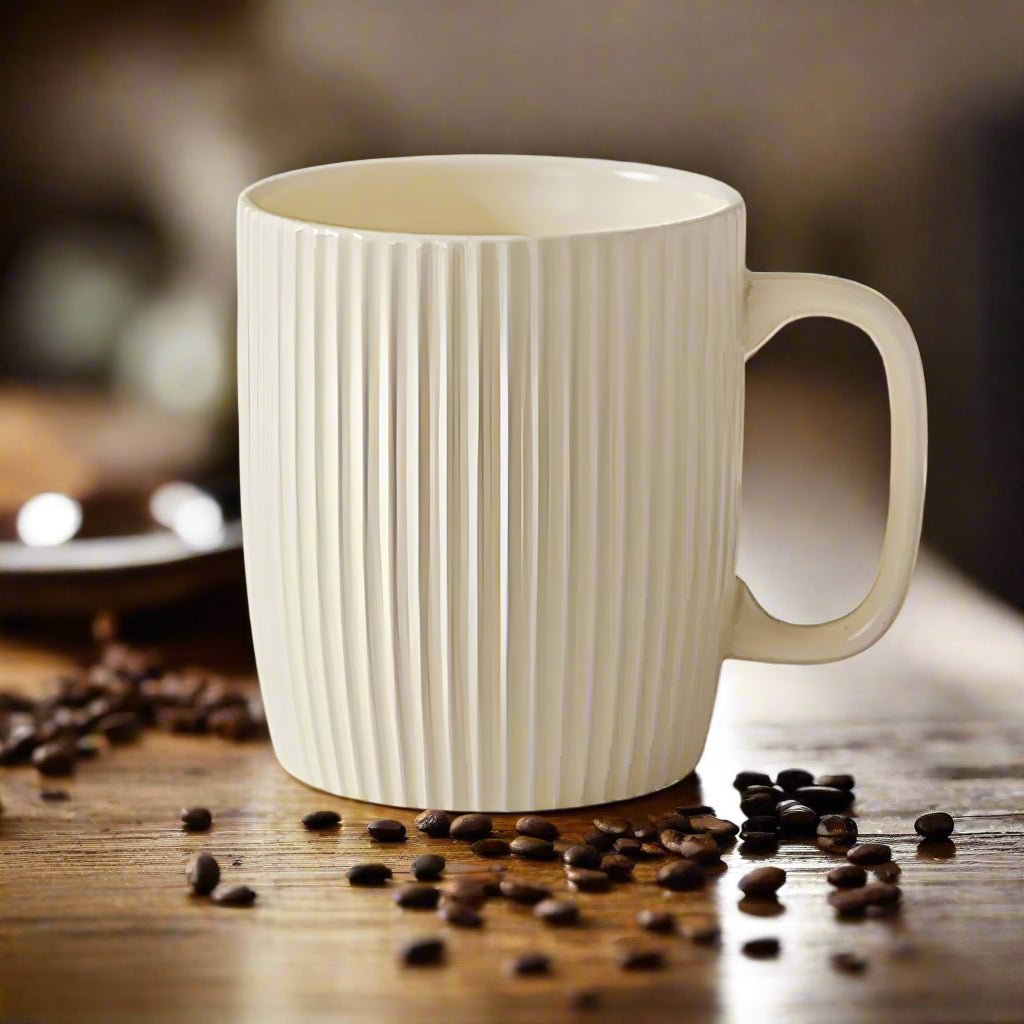 White ceramic mug with ribbed texture on a wooden surface with scattered coffee beans.