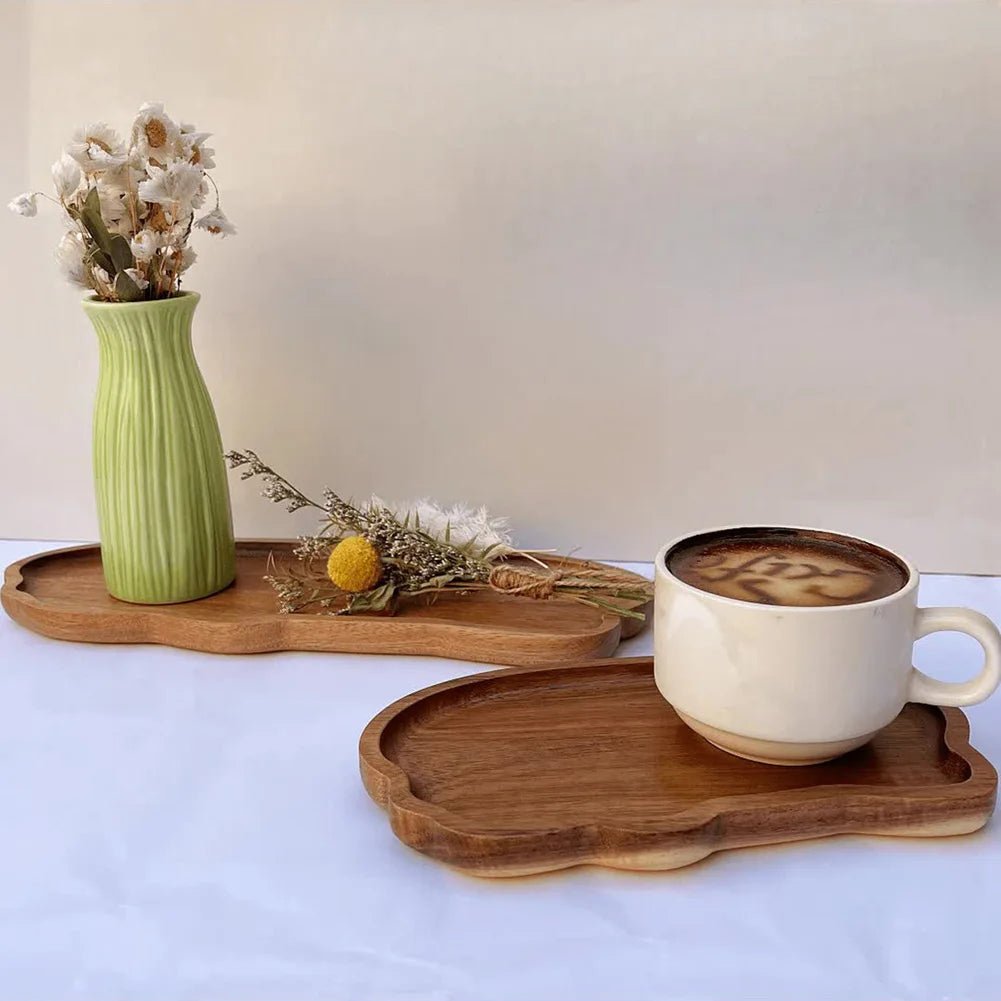 Wooden trays with a cup of coffee, vase, and dried flowers on a light background