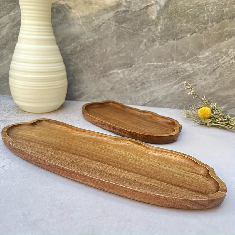 Two wooden trays on a marble surface with a vase and flowers in the background.