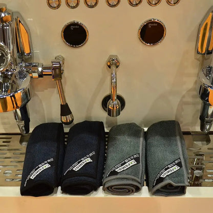 Four pairs of socks in black and gray on a shelf with beer taps in the background.