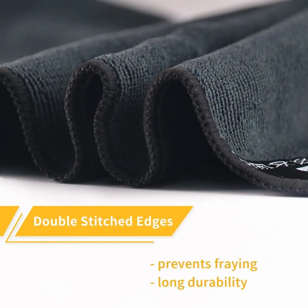 Close-up of dark fabric with double-stitched edges and text on a white background