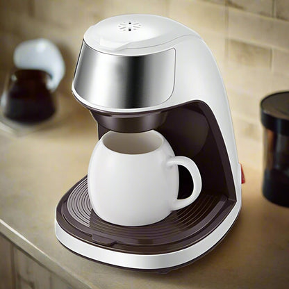 White coffee maker with a white cup on a kitchen counter