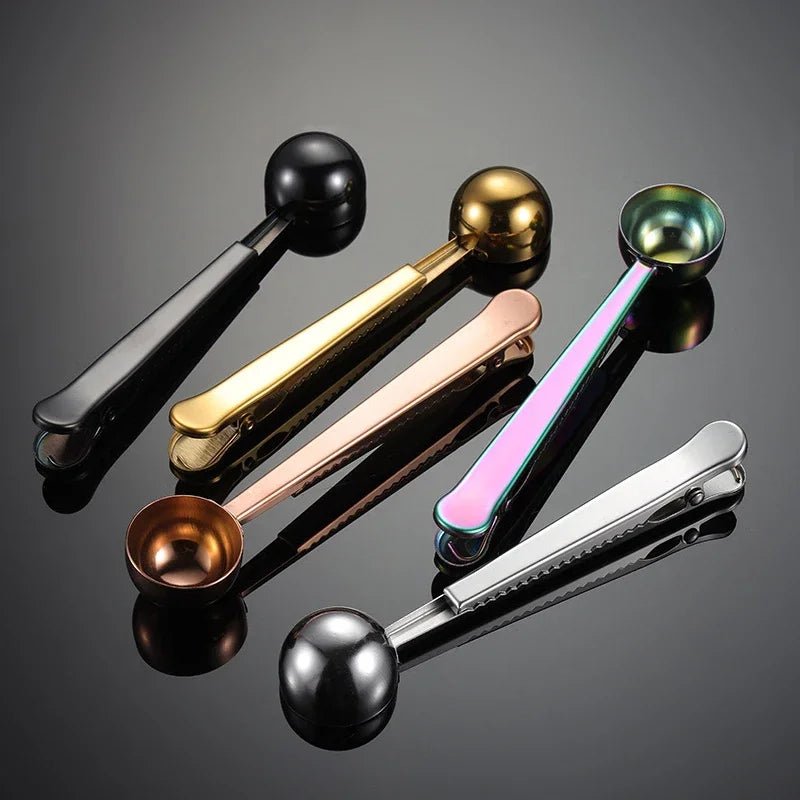 Set of five metal measuring spoons in different colors on a reflective surface.