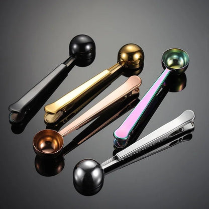 Set of five metal measuring spoons in different colors on a reflective surface.