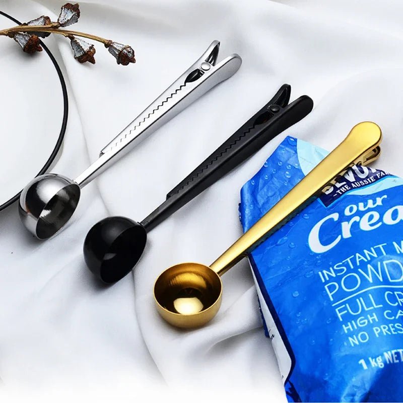Set of measuring spoons on a white surface with a blue packet of instant coffee.