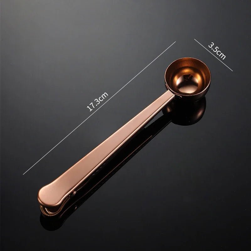 Rose gold measuring spoon with dimensions on a black background