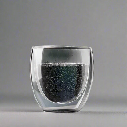Double-walled glass with black interior on a gray background