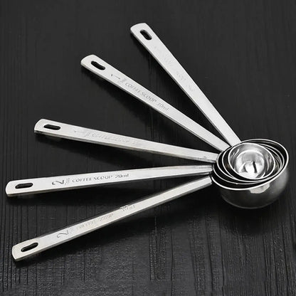 Set of metal measuring spoons on a dark surface